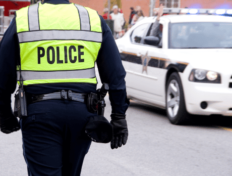 A police officer walking towards police car