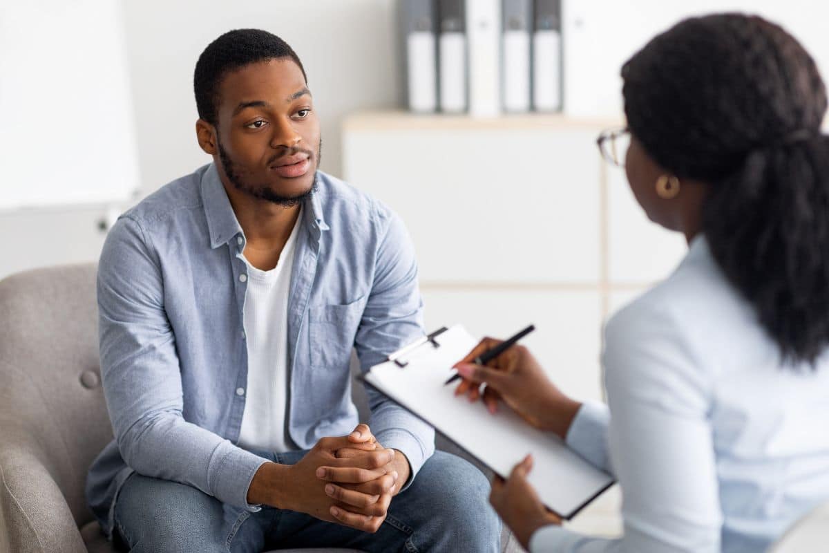 Homem negro conversando com um conselheiro de saúde mental