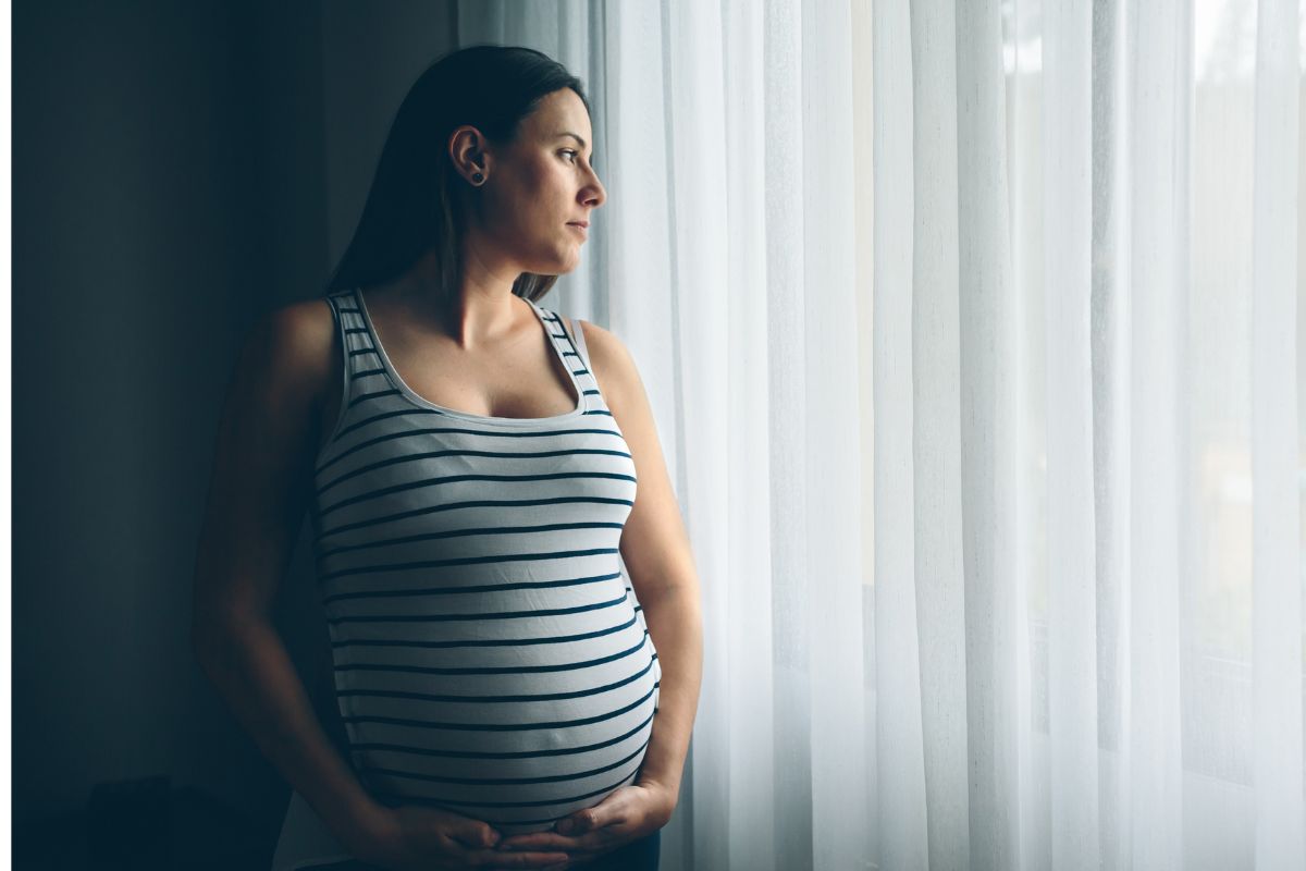 Pregnant mom looking out window Pregnant mom looking out window