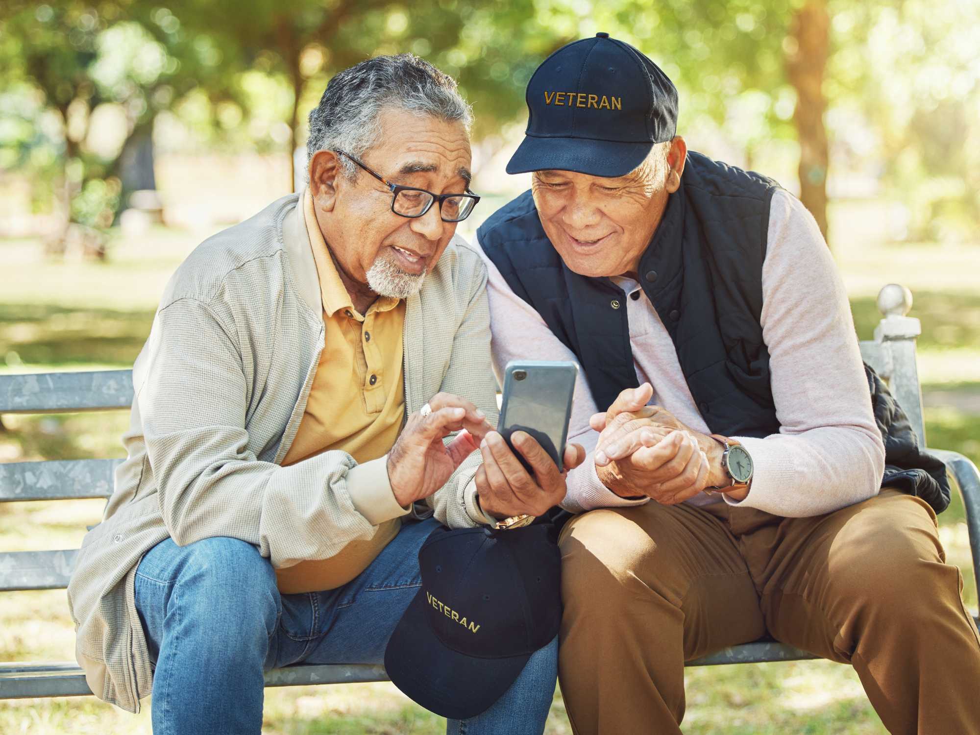 two older veterans helping each other at park