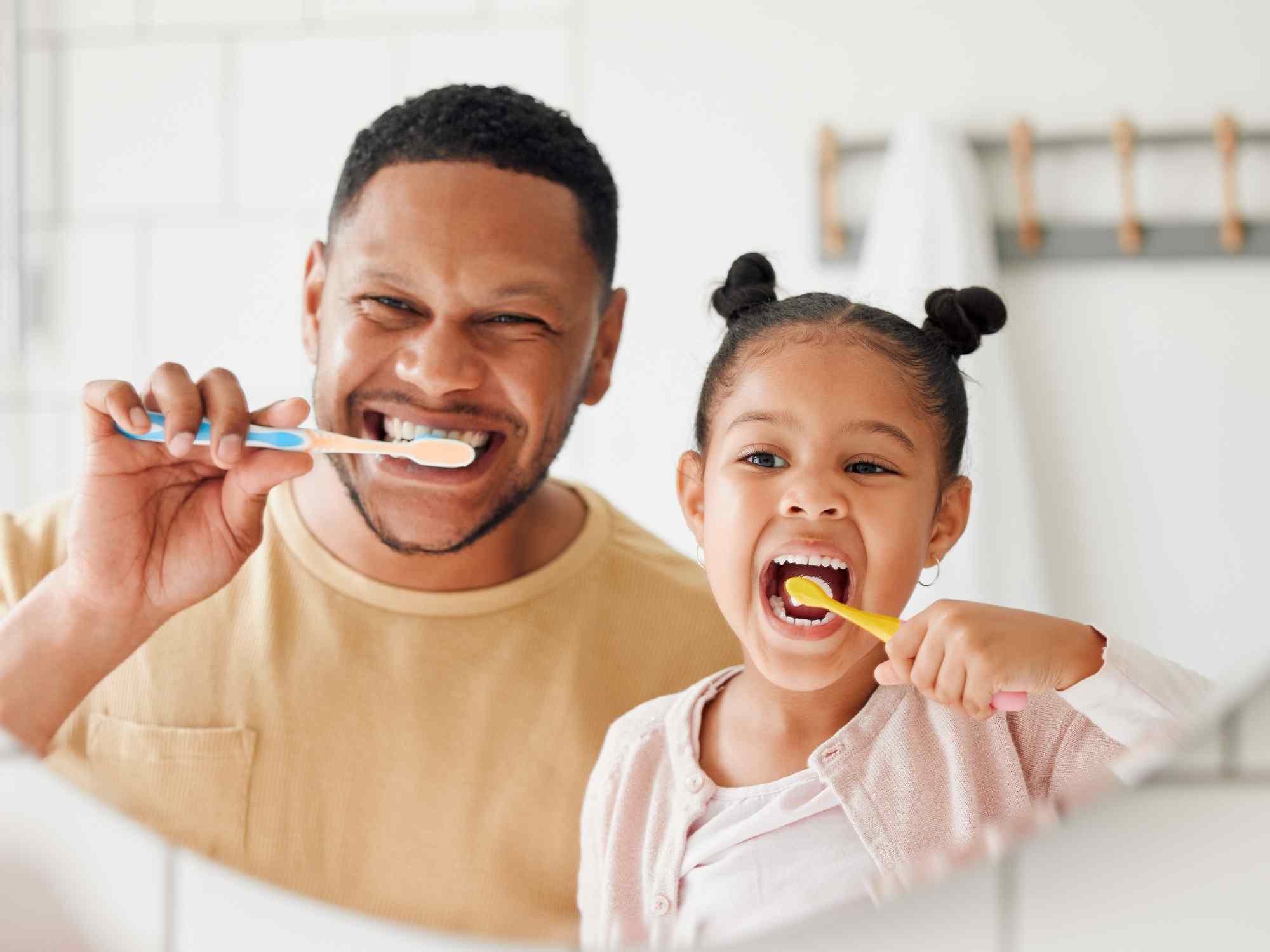 dad and daughter brushing teeth