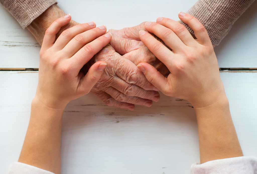 Young hands holding elderly hands