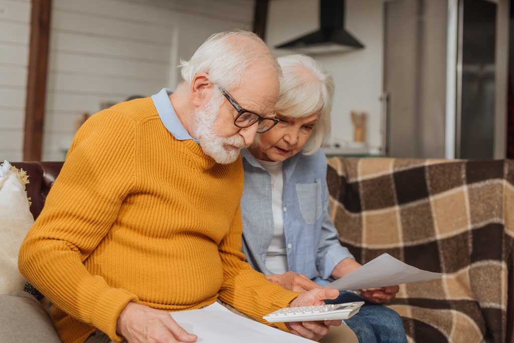 An elderly couple looking at a calculator