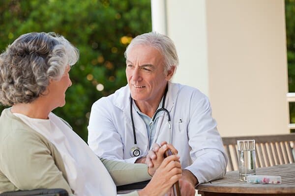 Doctor and older woman talking outside