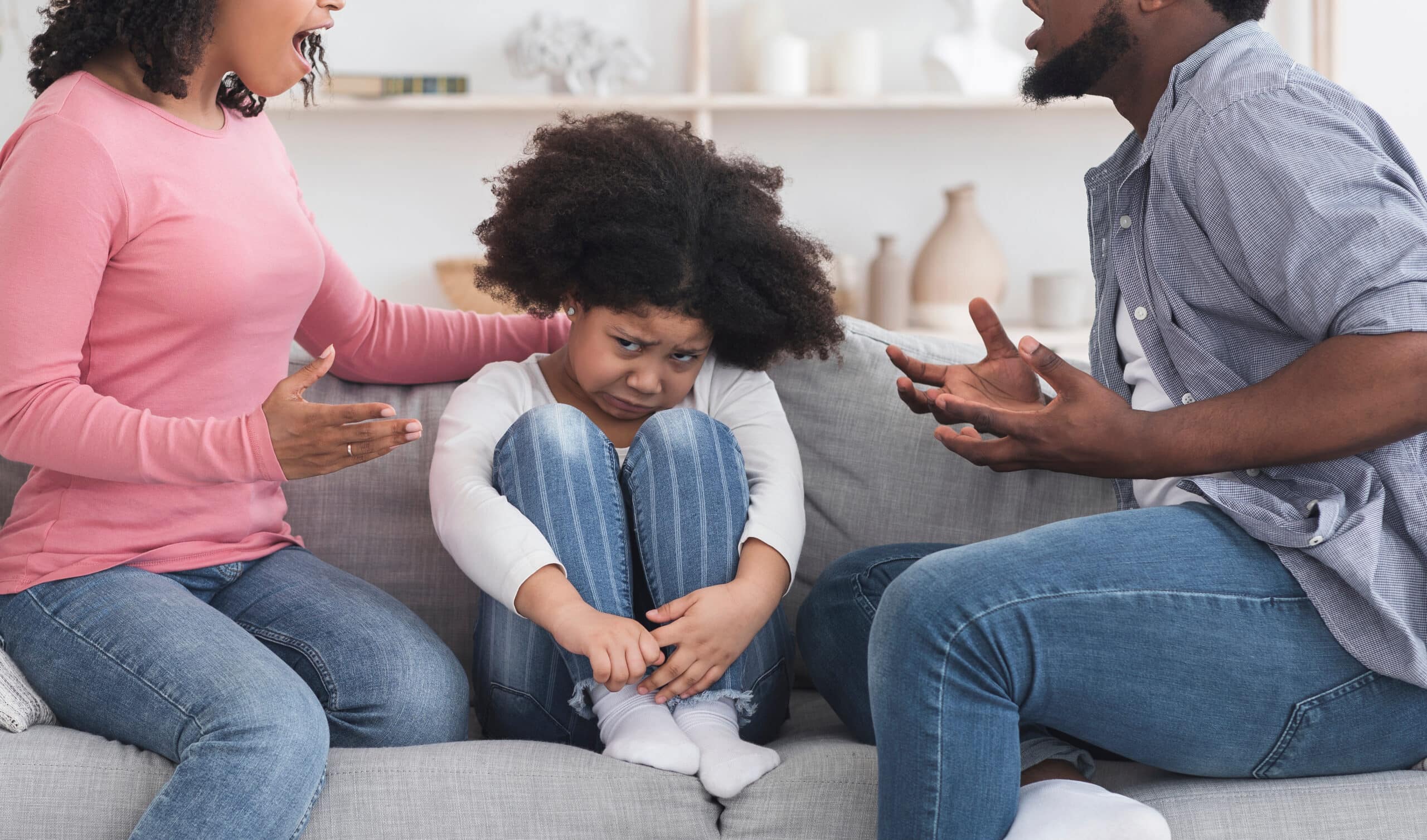 Parents se battant avec une petite fille qui a l'air effrayée