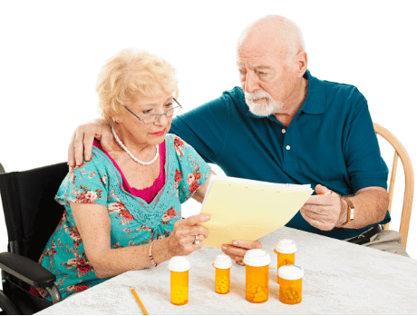 Elderly couple looking worried at medication papers