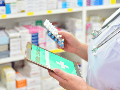 Pharmacist holding medication and a phone