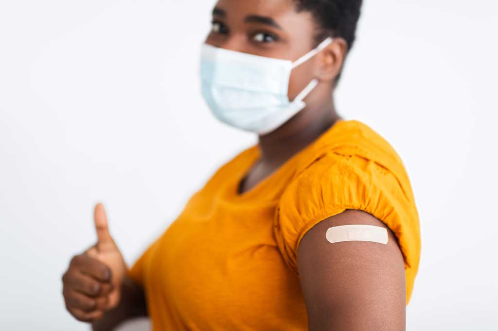 African American woman giving thumbs up after COVID-19 vaccine