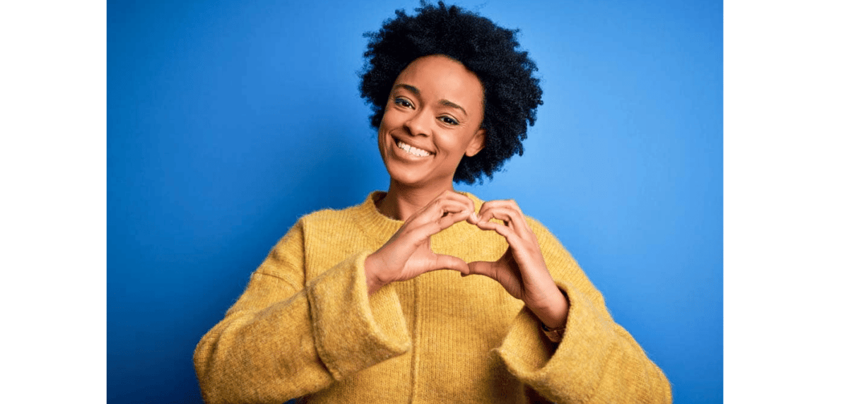 Black woman holding her hands in shape of a heart