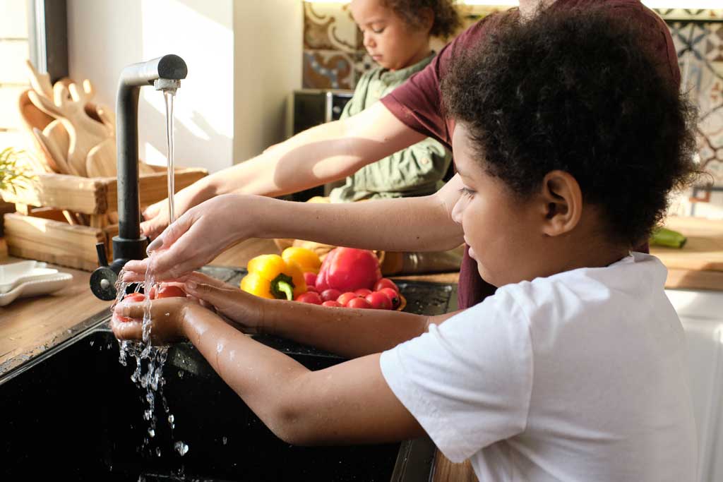 famiglia lavarsi le mani con acqua