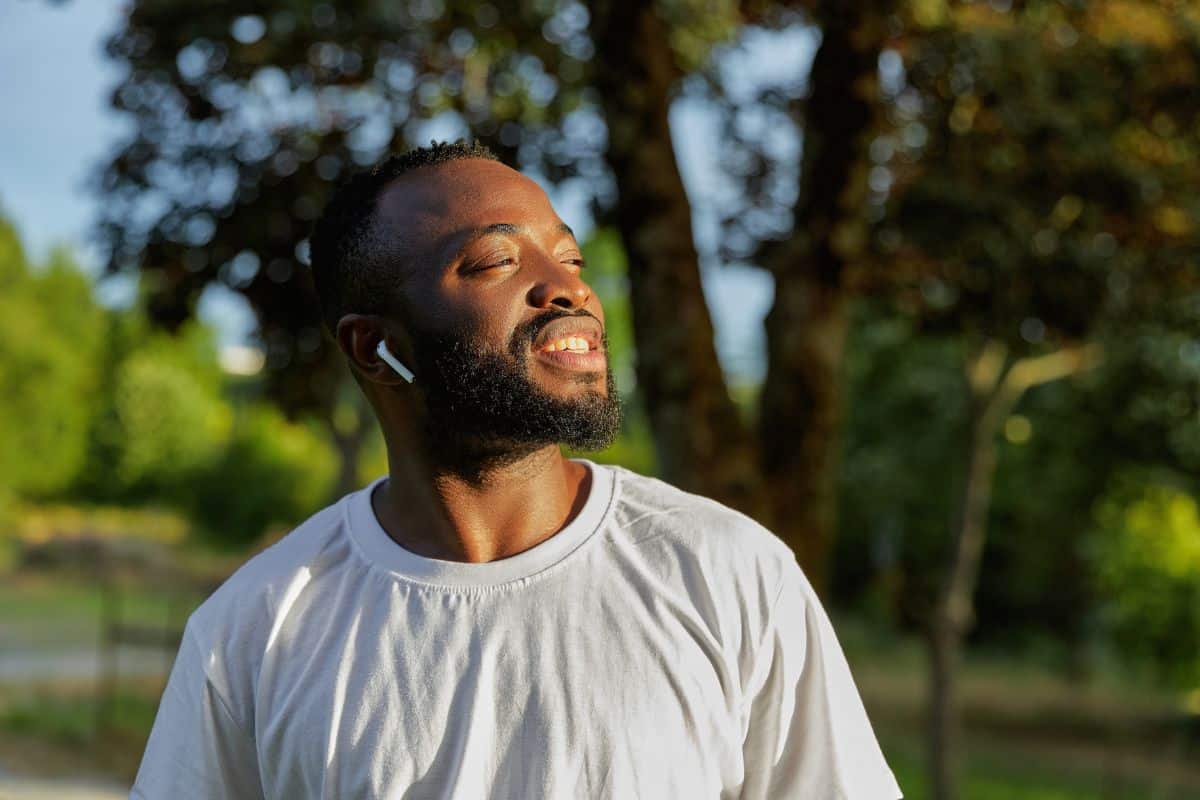 Black man looking optimistically to the sky because he's managed stress