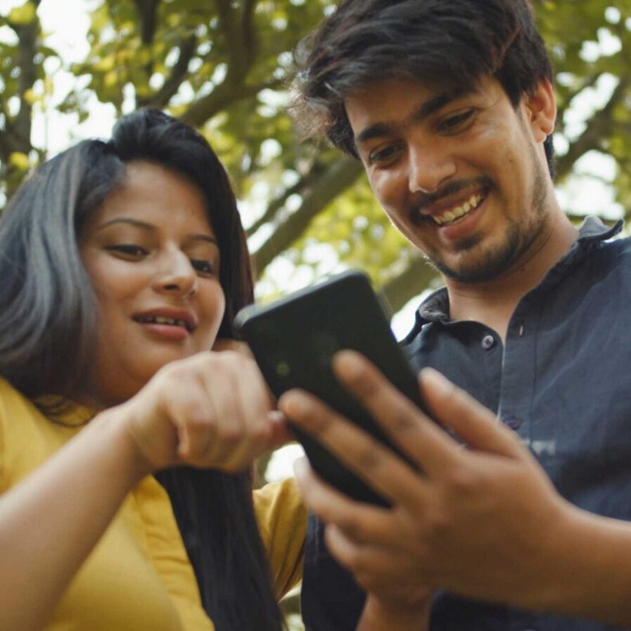 Couple looking for help on phone in park