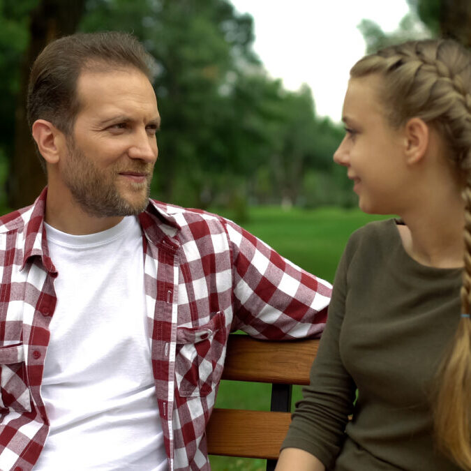 Dad talking to his child on park bench