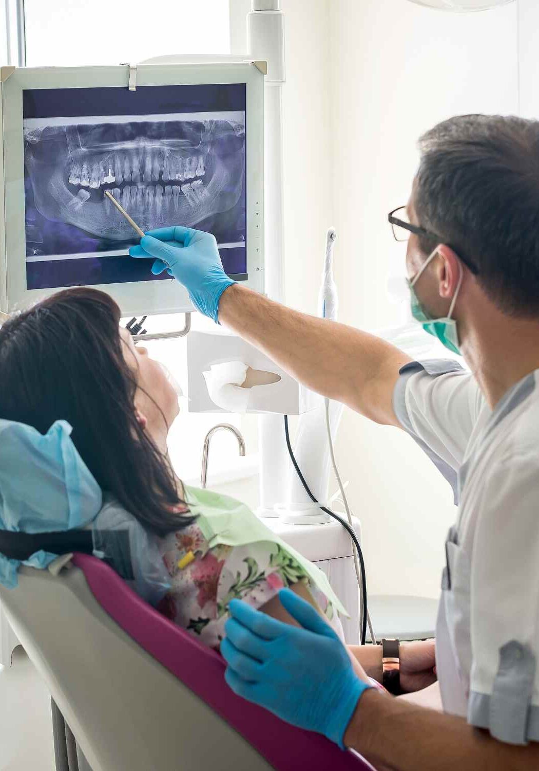 Dentist showing patient xrays of tooth at dental clinic