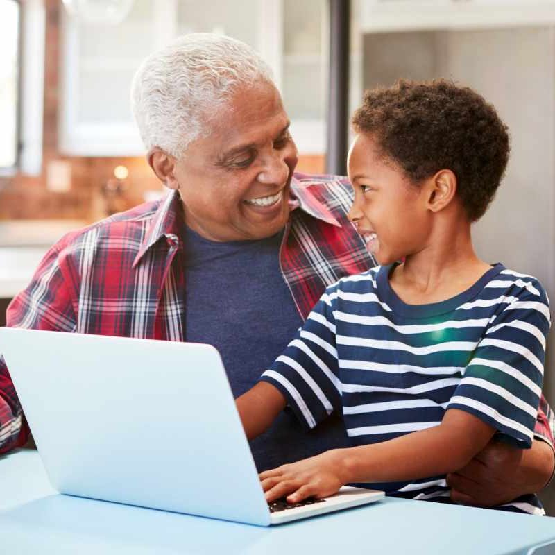 Grandfather on computer with grandson