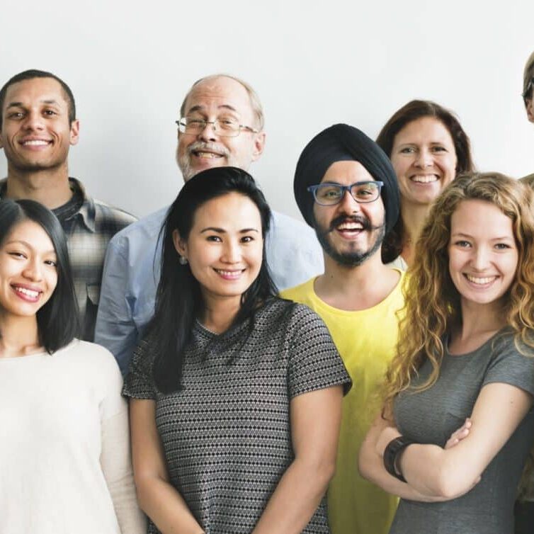 Un groupe diversifié de personnes souriant à la caméra