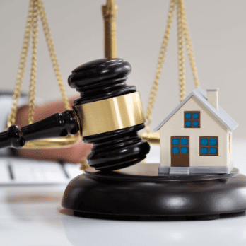 Legal gavel with a plastic model of a house next to it