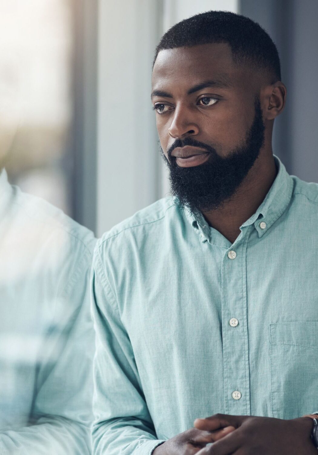 Man looking out window thinking