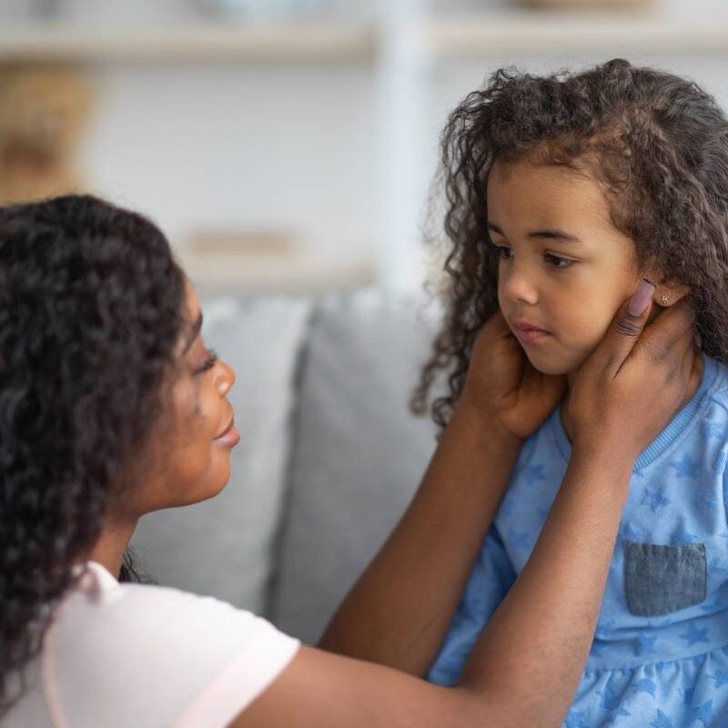 妈妈在逆境中安慰女儿，抓着她的脸