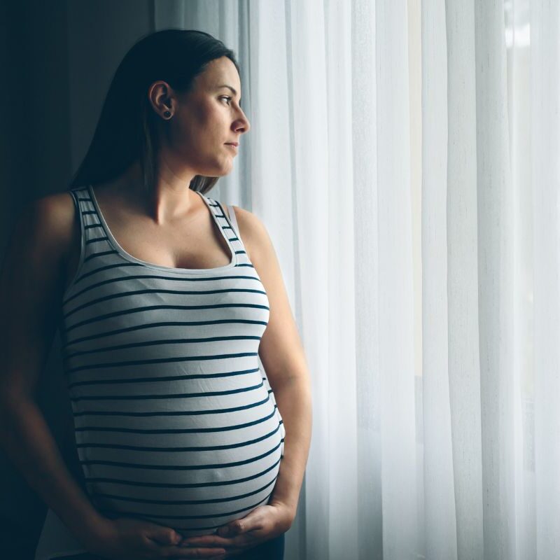 Pregnant mom looking out window