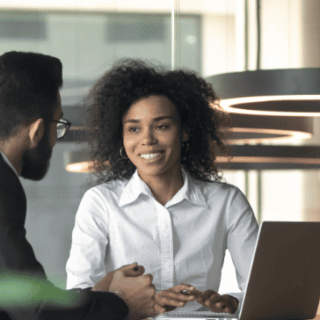 A man and a woman talking over a computer