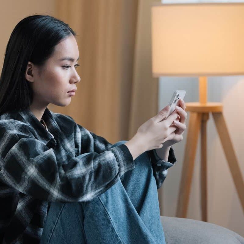 teen on phone looking sad