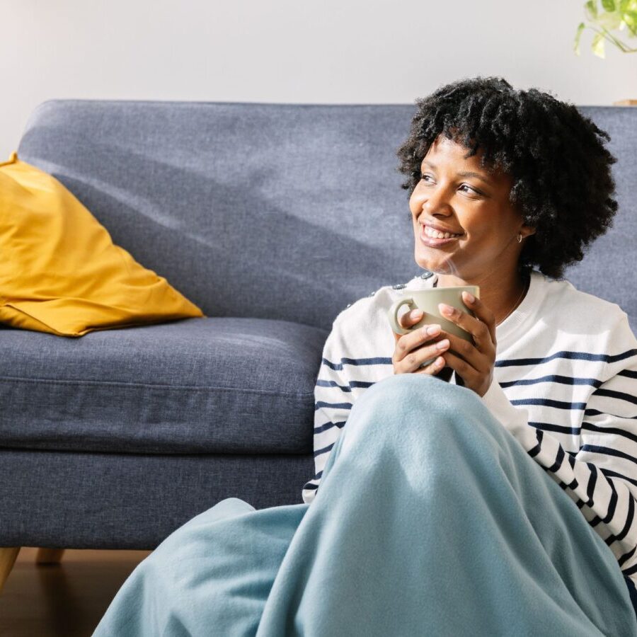 Woman drinking coffee warm at home during winter