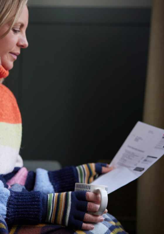 Cold woman looking at heating bill