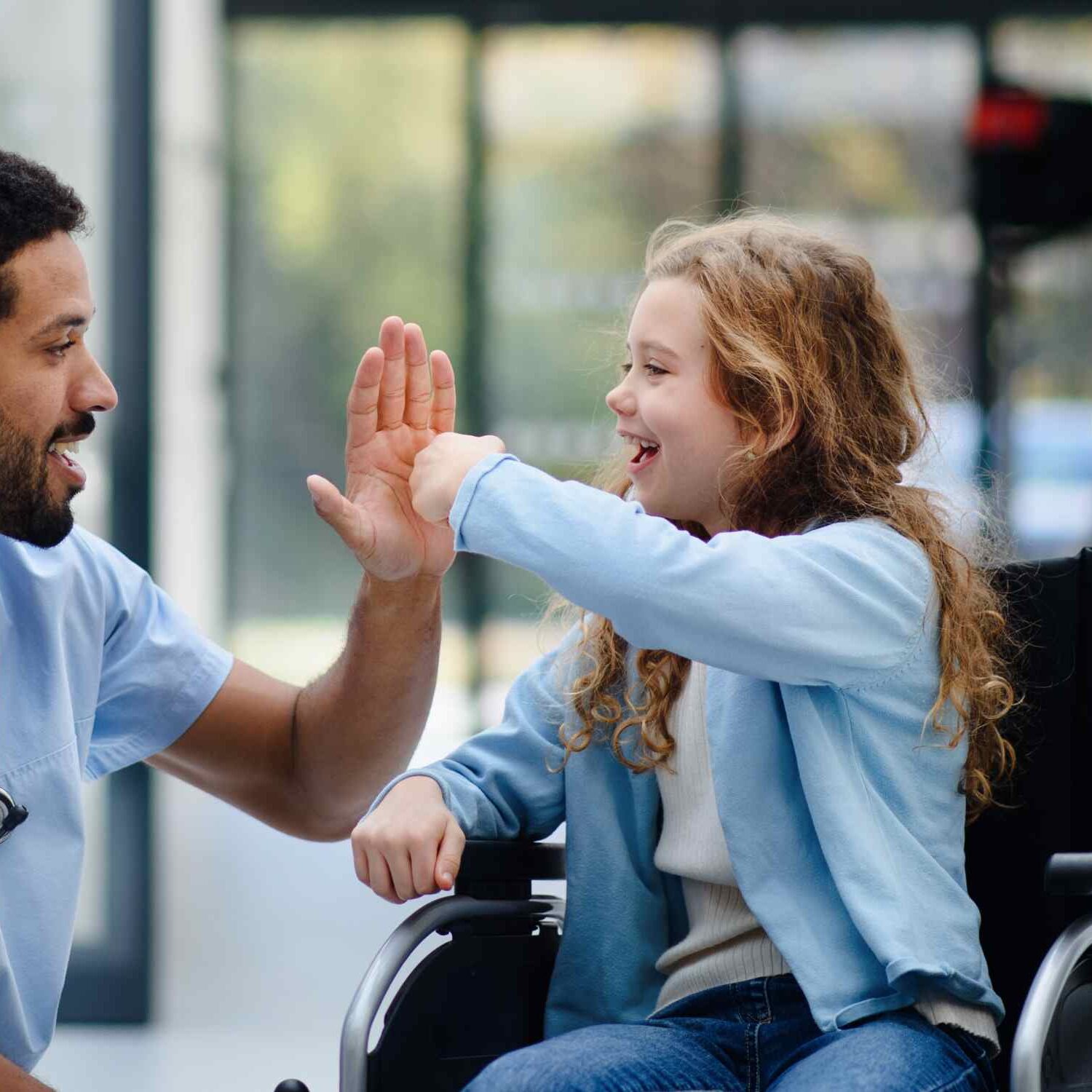 girl in wheelchair high fiving doctor