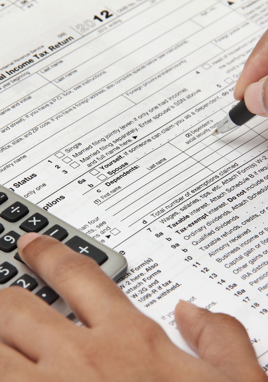 person doing taxes, filling out 1040 form